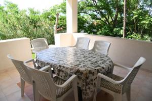a table and chairs sitting on a porch with a table and chairs at Apartments by the sea Bosana, Pag - 22692 in Pag +30 photos