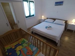 a small bedroom with a bed and a window at Apartments by the sea Bosana, Pag - 22692 in Pag