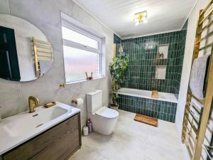 a bathroom with a sink and a toilet and a tub at Beautiful 2 BR home close to the city in Morpeth