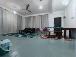 a living room with a ping pong table and chairs at D'Aqiela Gayang Homestay in Tuaran