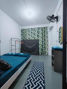 um quarto com uma cama com um edredão azul em D'Aqiela Gayang Homestay em Tuaran