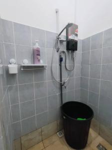 a bathroom with a shower with a black bucket at D'Aqiela Gayang Homestay in Tuaran