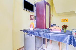 cocina con mesa y mantel azul en OYO Hotel Faizalia Tourist Home, en Perumpāvūr