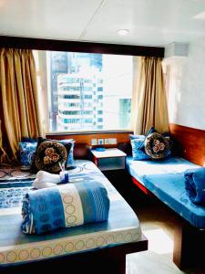 a bedroom with two beds and a large window at Asia inn (Block B) in Hong Kong
