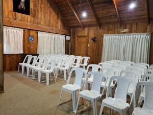 una stanza piena di sedie bianche in un fienile di Riverview Lodge a Hanmer Springs
