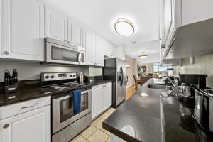 uma cozinha com armários brancos e electrodomésticos de aço inoxidável em Marina appartement with beach view em Los Angeles