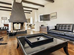 a living room with a leather couch and a fireplace at 20 person holiday home in Svendborg in Svendborg