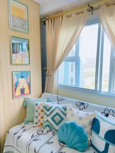 ein Schlafzimmer mit einem Bett mit Kissen und einem Fenster in der Unterkunft Pineview Haven in Baguio in Baguio City