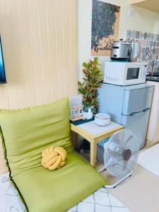 ein grünes Sofa mit einem Tisch und einer Mikrowelle in der Unterkunft Pineview Haven in Baguio in Baguio City