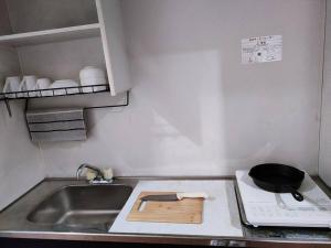a small kitchen with a sink and a stove at Home Stay 北国分 in Ichikawa