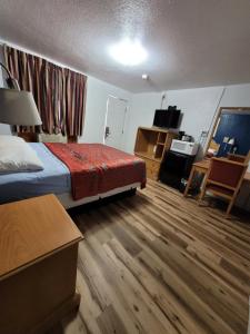 una camera d'albergo con letto e scrivania di Sands Motel a Portales