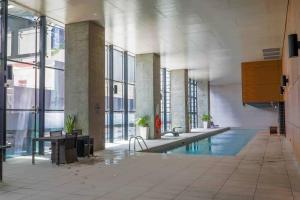 a large room with a swimming pool in a building at Best location in the CBD; pool, gym, rockclimbing +7 other amenities in Melbourne