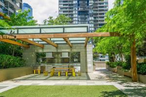 a patio with a picnic table and yellow benches at Best location in the CBD; pool, gym, rockclimbing +7 other amenities in Melbourne
