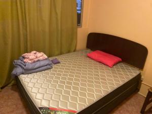 Schlafzimmer mit einem Bett mit rotem Kissen und Avertisation in der Unterkunft Baquedano in Antofagasta