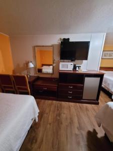 una camera d'albergo con due letti e una televisione di Sands Motel a Portales