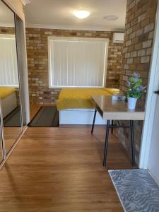 a living room with a couch and a table at Spacious studio unit in Rochedale South