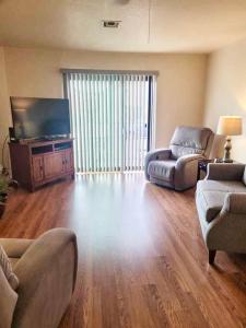 a living room with a couch and a tv at 1st Floor Condo in the Desert w/ Pool, Spa & BBQ in Lake Havasu City
