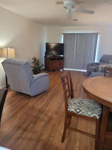 a living room with a table and chairs and a tv at 1st Floor Condo in the Desert w/ Pool, Spa & BBQ in Lake Havasu City