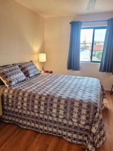 a bedroom with a bed and a window with blue curtains at 1st Floor Condo in the Desert w/ Pool, Spa & BBQ in Lake Havasu City