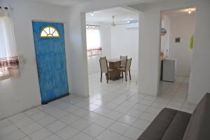 a room with a blue door and a table and chairs at Casa completa a 5 minutos de la playa en Crucecita Huatulco in Santa Cruz Huatulco