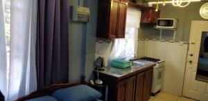 uma pequena cozinha com um lavatório e um fogão em Ali's Apartment em Hyde Park