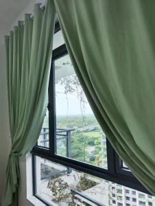 a window with green curtains in a room at Holiday SweetHome at Forest City 2BR1B with TV Box 4-6pax 1807 in Gelang Patah