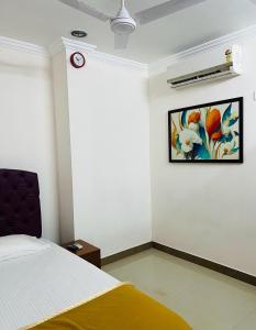 um quarto com uma cama e um quadro na parede em ROYAL INN em Trivandrum
