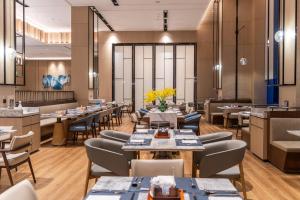 汕尾汕尾海丰万怡酒店的一间带桌椅的餐厅和一间餐厅