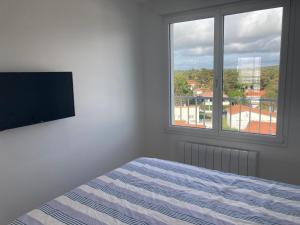 een slaapkamer met een bed, een televisie en een raam bij Appartement Saint-Jean-de-Monts, 3 pièces, 5 personnes - FR-1-323-230 in Saint-Jean-de-Monts