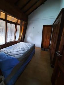 niewielka sypialnia z łóżkiem i oknem w obiekcie Villa As-salam, Kadungora, Garut w mieście Garut