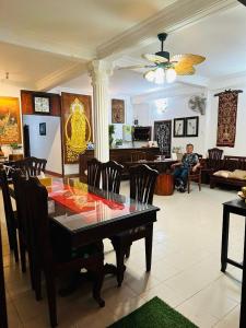 een eetkamer met een tafel en stoelen en een man bij Mano boutique sun shine in Luang Prabang