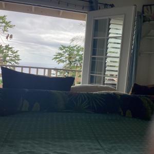1 cama con vistas al océano desde una ventana en Kona Hawaii Guest House a Unique Hawaii Experience, en Kailua-Kona