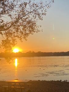 una puesta de sol sobre un lago con una mesa de picnic en Havre de paix, en Laval