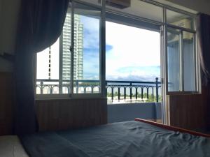 a bedroom with a large window with a view of the ocean at Tuệ Tĩnh Tower 21 in Nha Trang