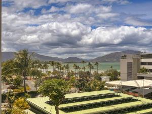 a view of the ocean and a resort with palm trees at La Perle Azurée in Noumea