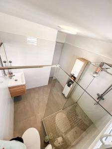 a bathroom with a glass shower and a toilet at La Perle Azurée in Noumea