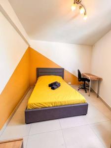 una camera con letto giallo e scrivania di La Perle Azurée a Noumea