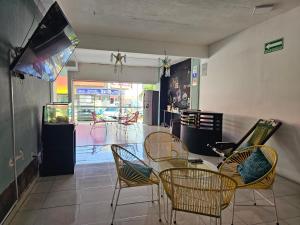 een eetkamer met stoelen en een tafel en een tv bij Hotel Regional San Marcos in Tuxtla Gutiérrez