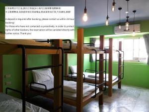 台東市的住宿－Peggy Home，配有双层床和绿色墙壁的客房