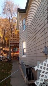 a house with a deck next to a building at Peaceful Mountain Home in West Homestead