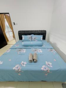 ein Bett mit zwei Paar Schuhen drauf in der Unterkunft Anaqi Homestay Tawau Sabah in Kampong Parit