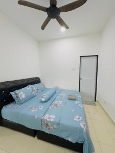 sypialnia z łóżkiem i wentylatorem sufitowym w obiekcie Anaqi Homestay Tawau Sabah w mieście Kampong Parit