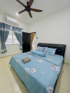 1 dormitorio con 1 cama azul y ventilador de techo en Anaqi Homestay Tawau Sabah, en Kampong Parit