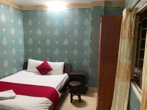 1 dormitorio con 2 camas y pared azul en Sophie hotel, en Hanói