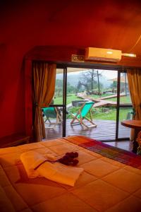 a bed in a room with a table and a view at Willkay Glamping Raco Tucumán in Tafí Viejo
