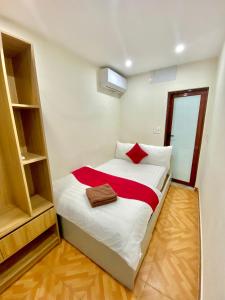 1 dormitorio pequeño con 1 cama con sábanas blancas y rojas en Sophie hotel, en Hanói