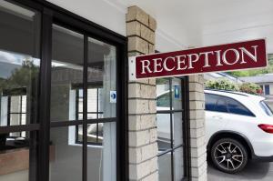 a white car parked in front of a store at BK's Pohutukawa Lodge in Whangarei