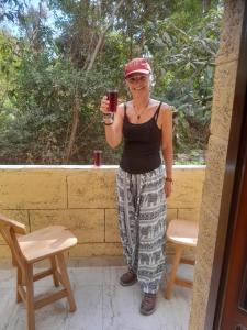Kashta Guest House & Hostel في أسوان: امرأة تمسك بزجاج احمر