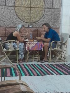 Kashta Guest House & Hostel في أسوان: رجل وامرأة يجلسون على طاولة