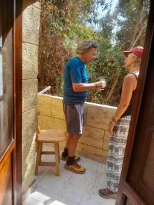 un hombre y una mujer de pie junto a una silla en Kashta Guest House & Hostel, en Asuán